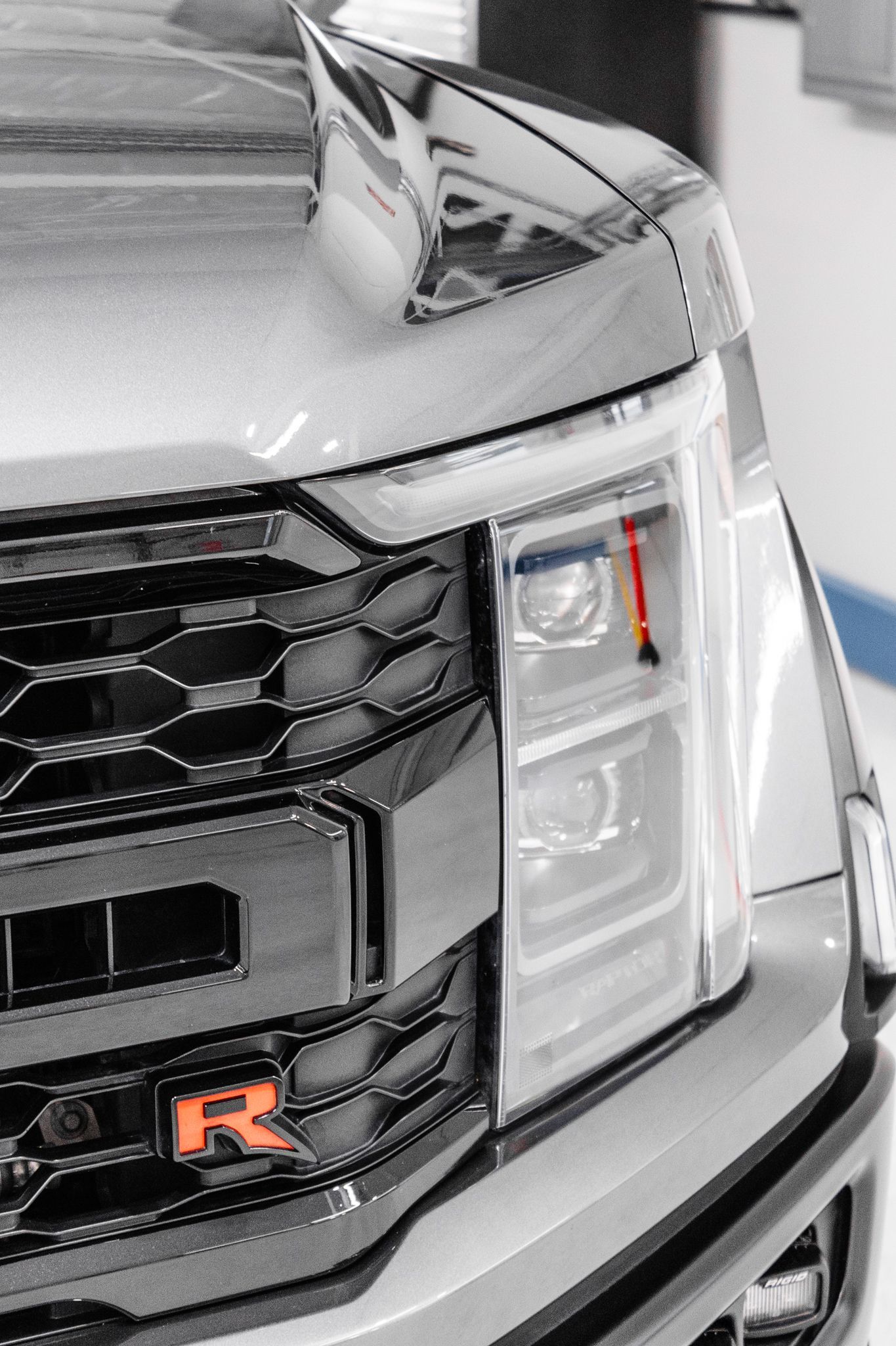 A close up of the hood of a silver corvette