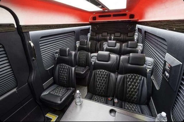 The inside of a van with black seats and a table