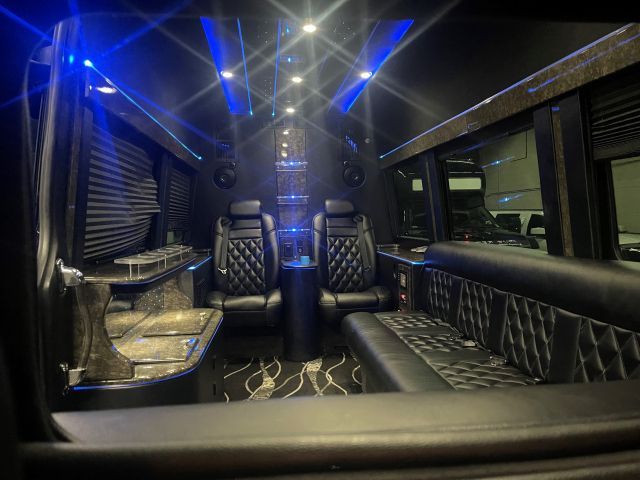 The inside of a luxury van with blue lights on the ceiling.