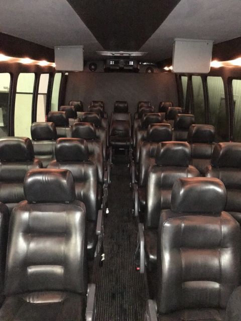 The inside of a bus with lots of black seats