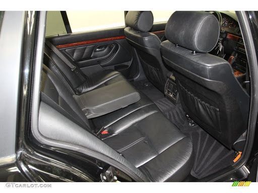 The back seat of a black bmw is shown.