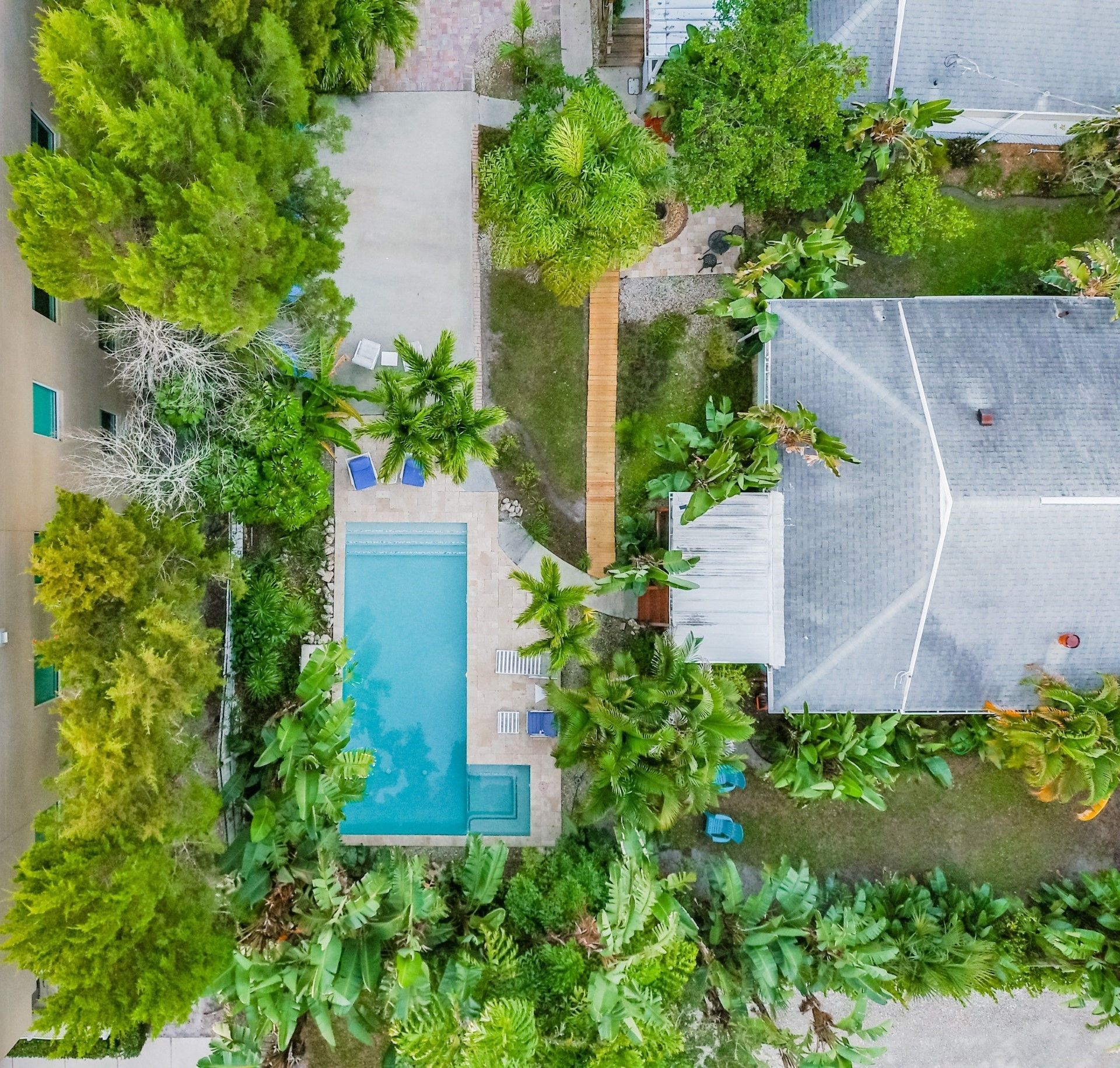 An aerial view of a house with a pool and palm trees