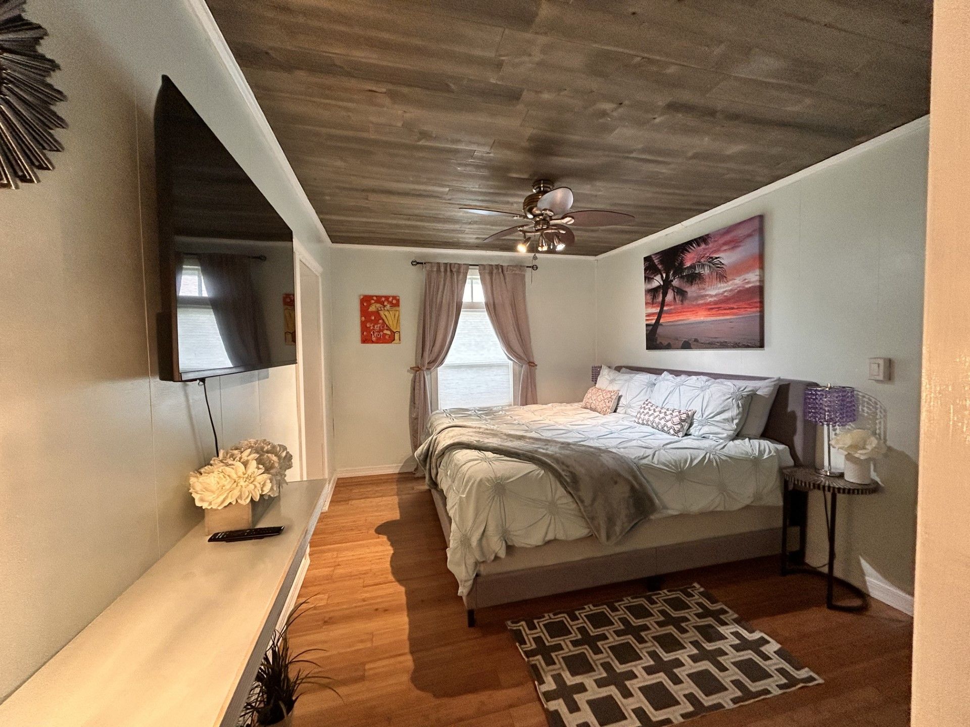 A bedroom with a large bed and a flat screen tv