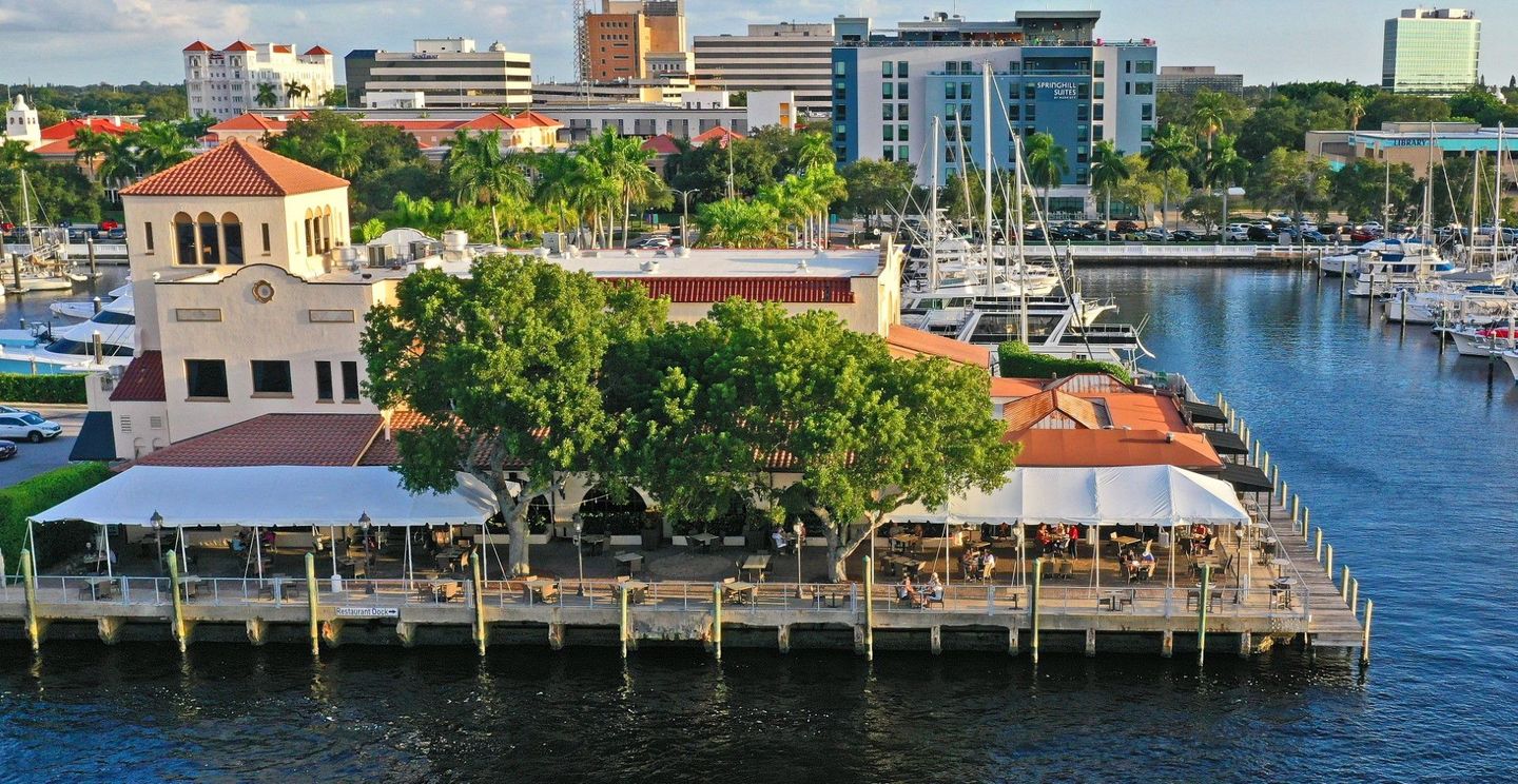 An aerial view of a marina with boats and buildings in the background