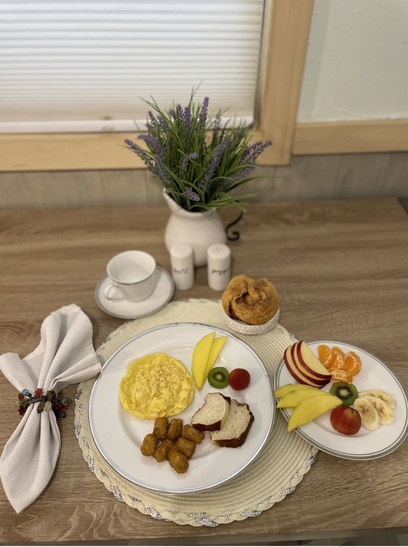 A table topped with plates of food and a vase of flowers.