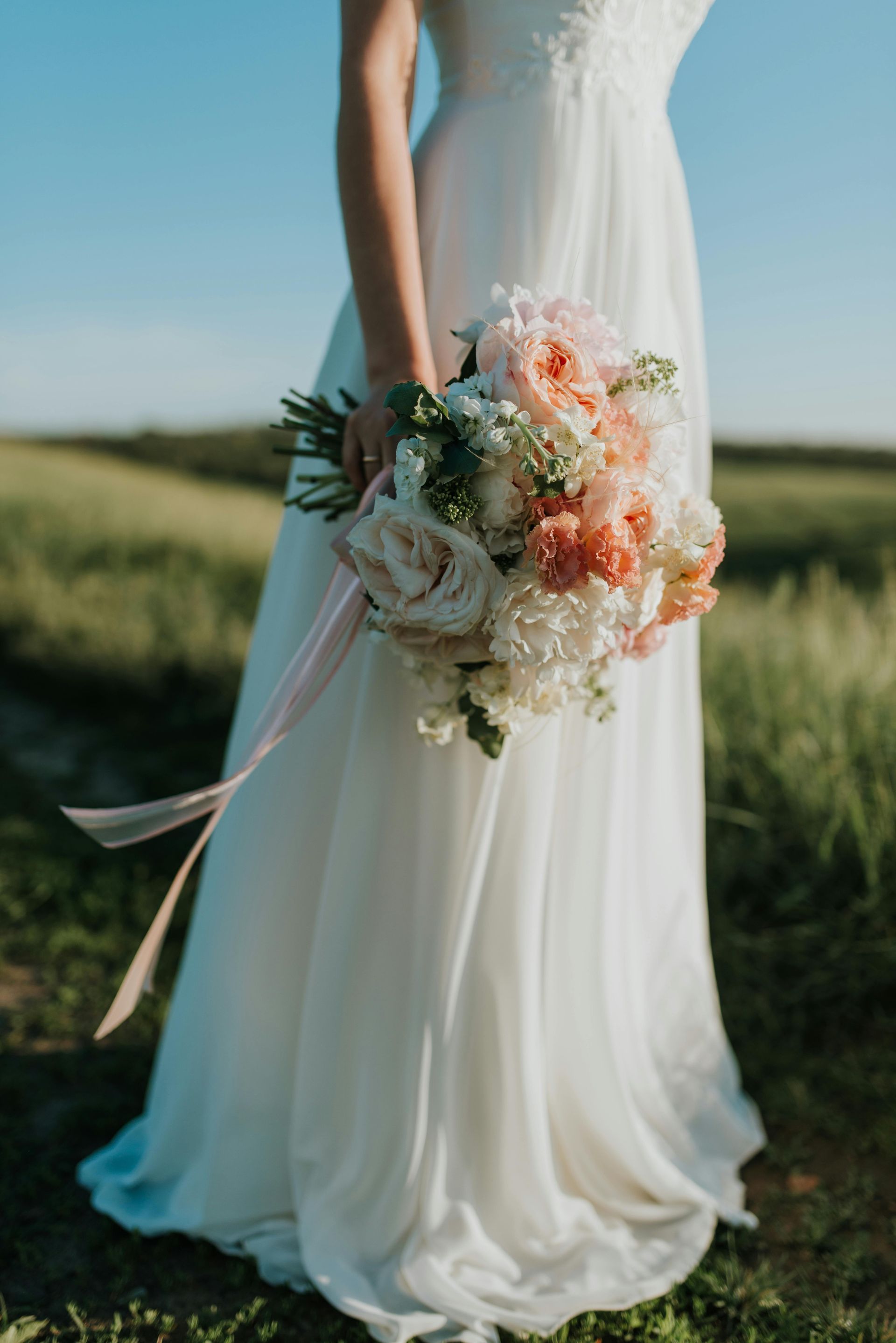 A bride in a white dress is holding a bouquet of flowers.