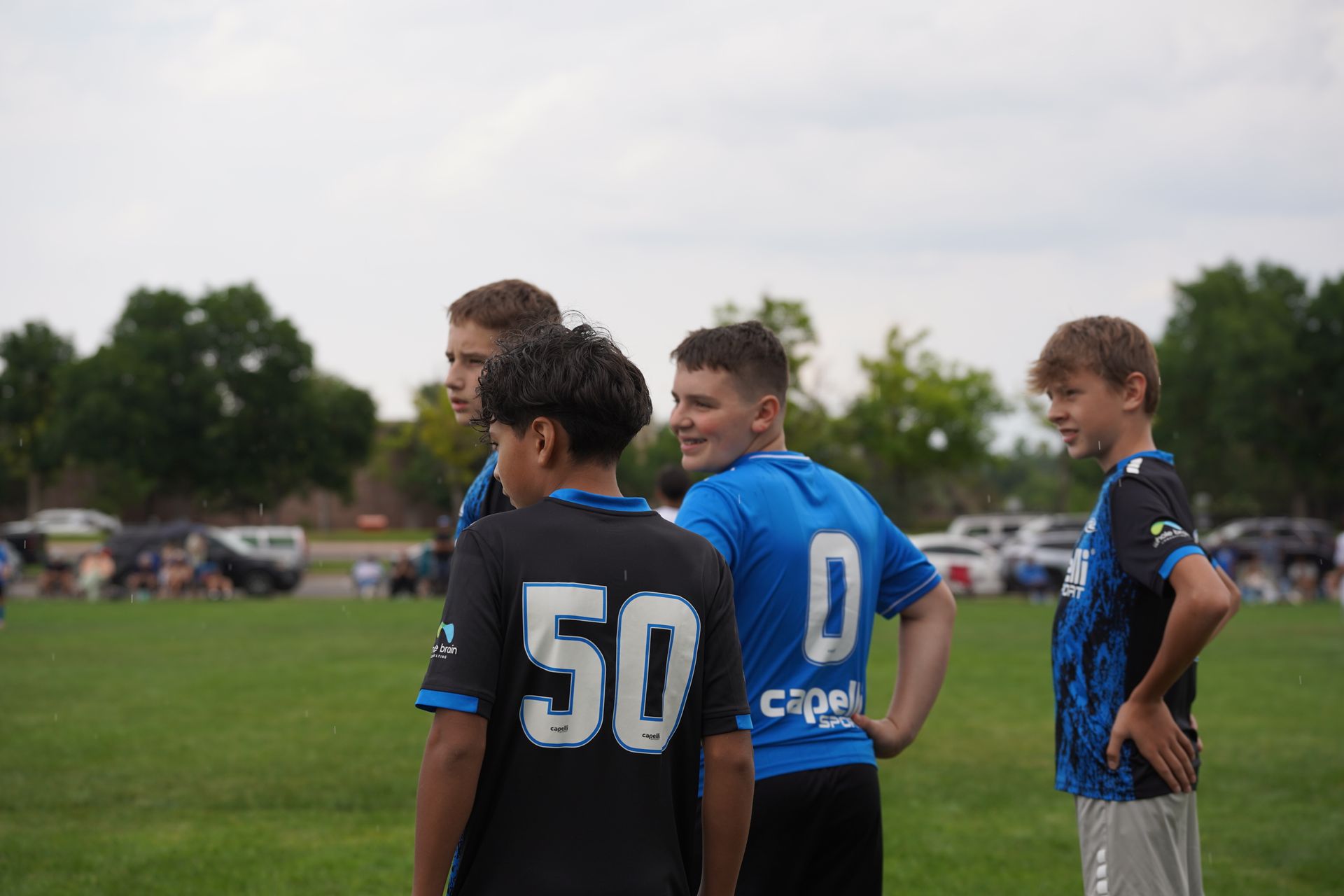 Two soccer players are playing a game of soccer on a field.