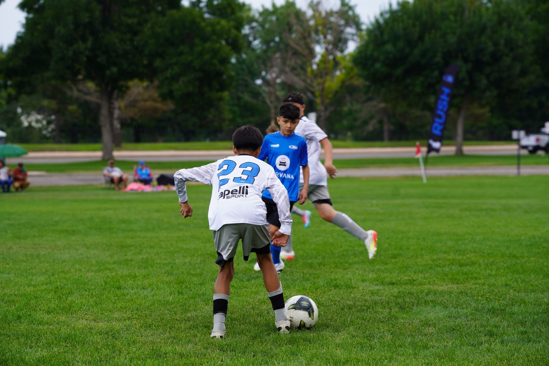 Two soccer players are playing a game of soccer on a field.