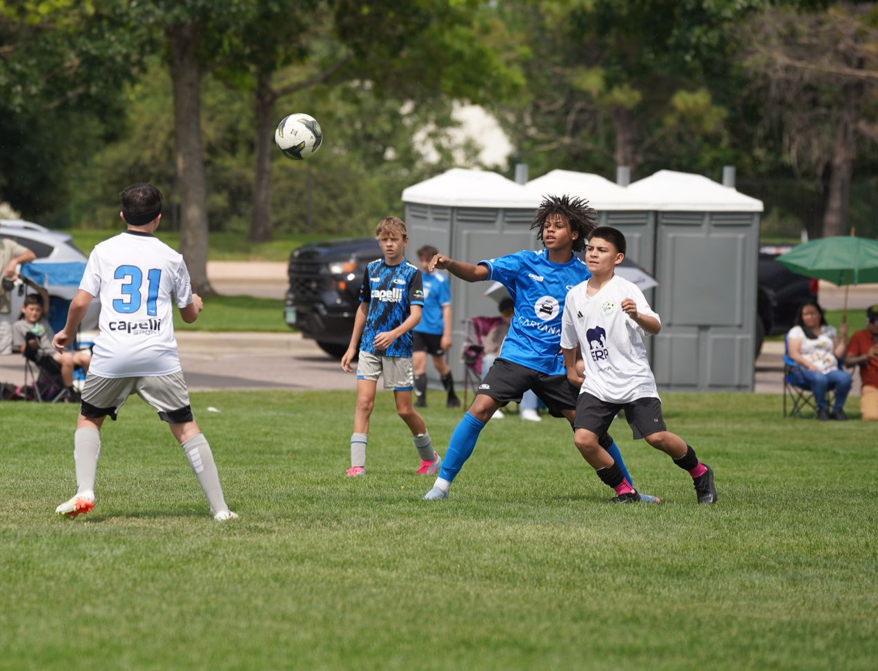 A group of young boys are playing soccer on a field.
