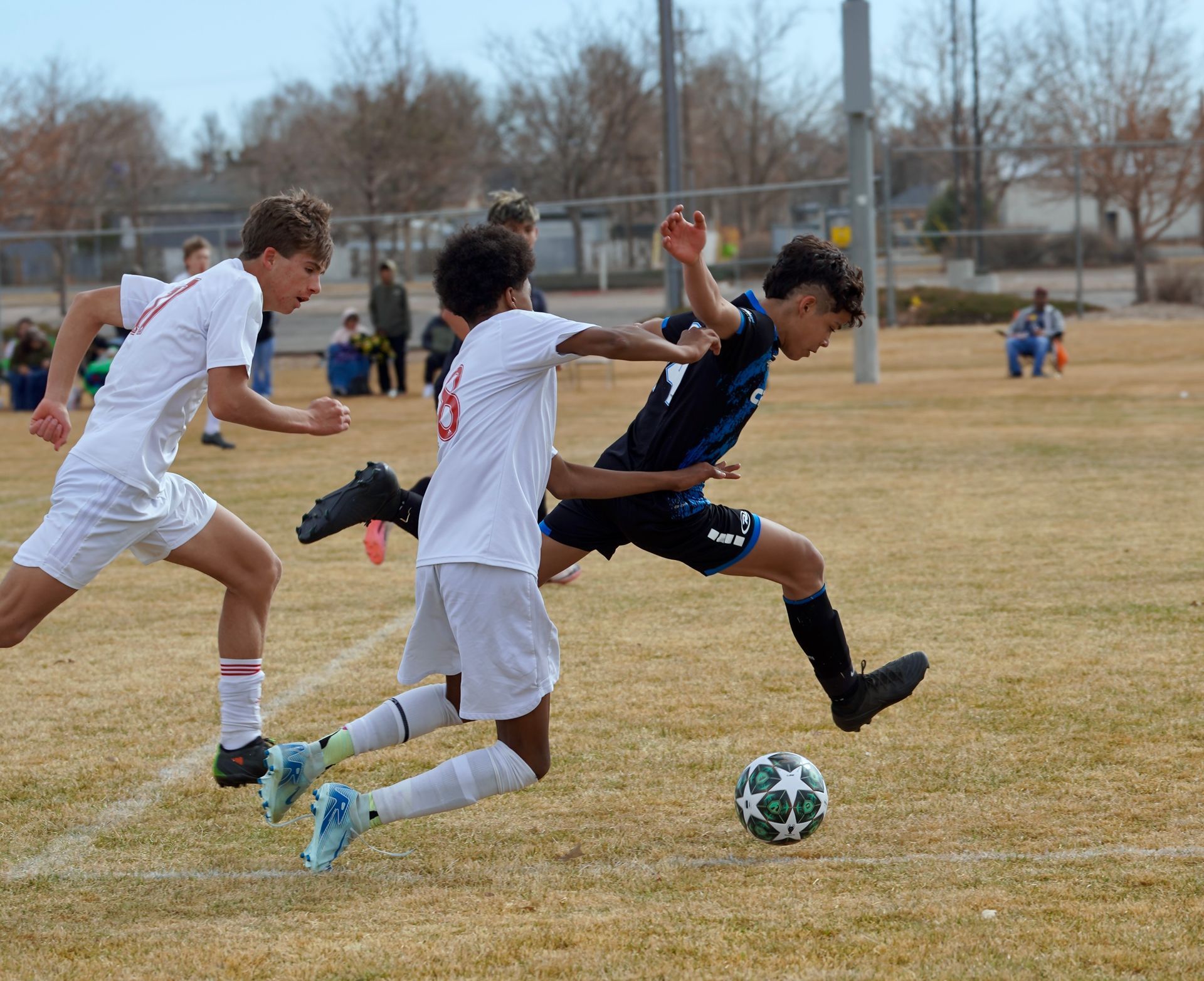 Two young girls are playing soccer on a field.