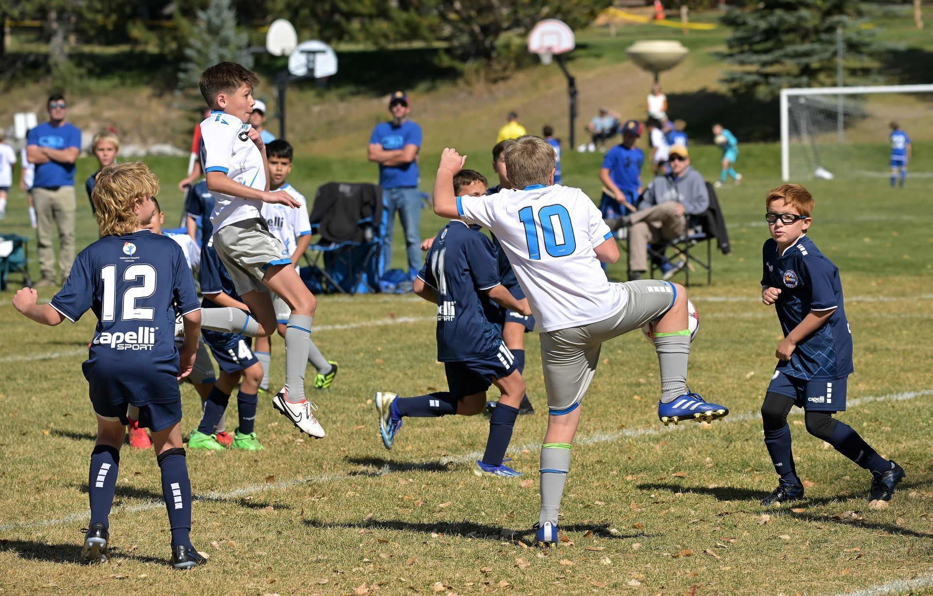 A group of young boys are playing soccer on a field.