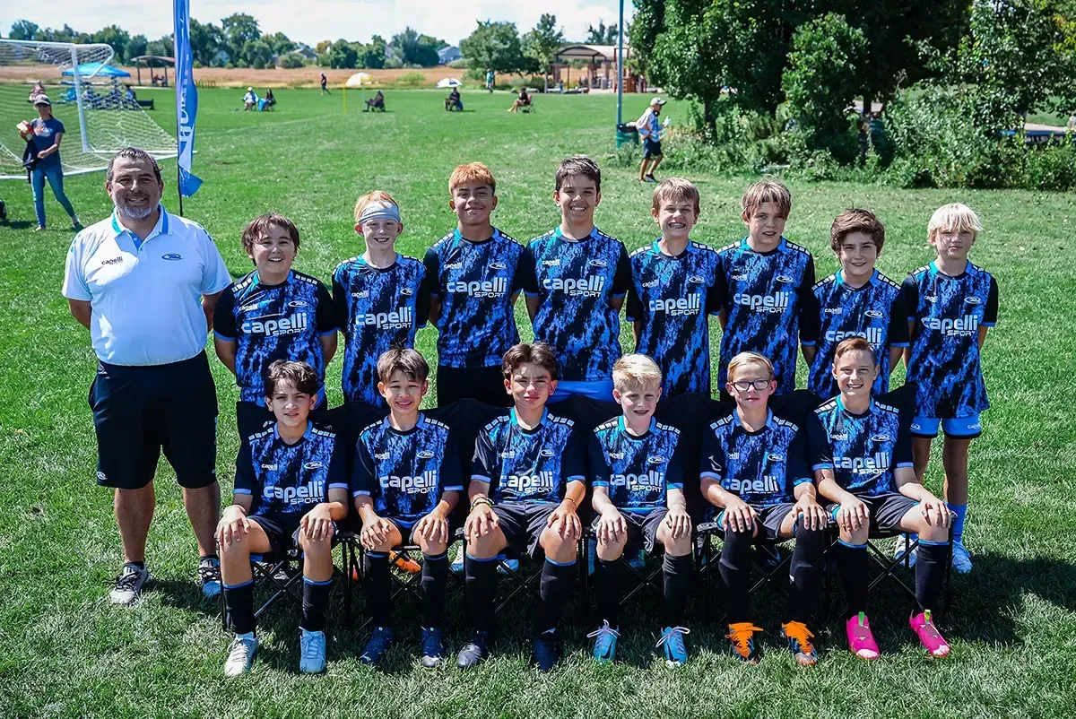 A group of young boys are posing for a picture on a soccer field.