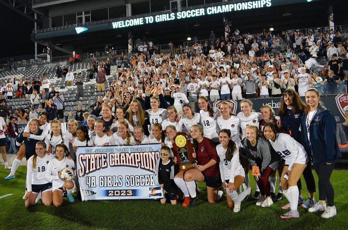 A soccer team is posing for a picture on the field.