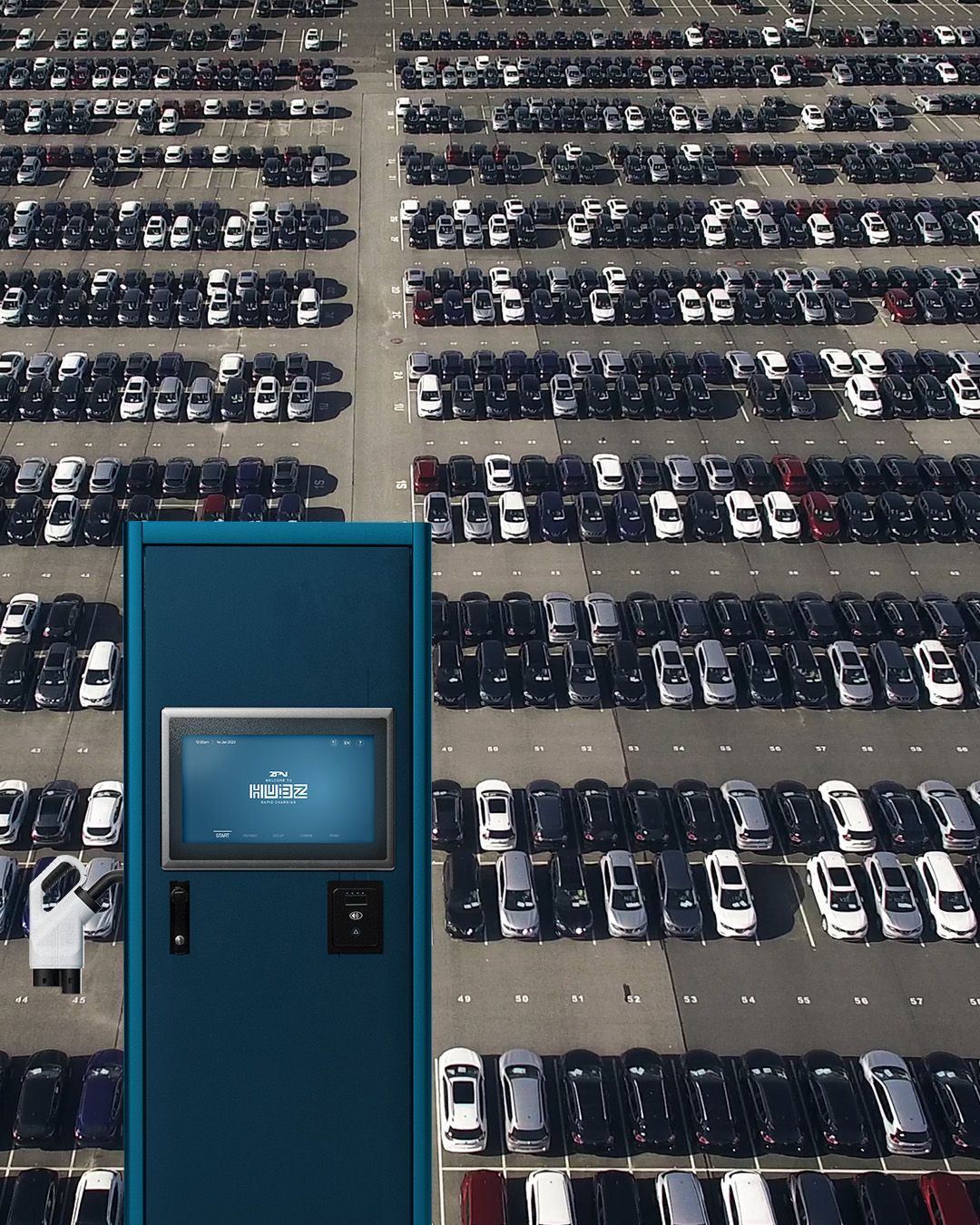 An aerial view of a parking lot with lots of cars and a hubz charger imposed on it 