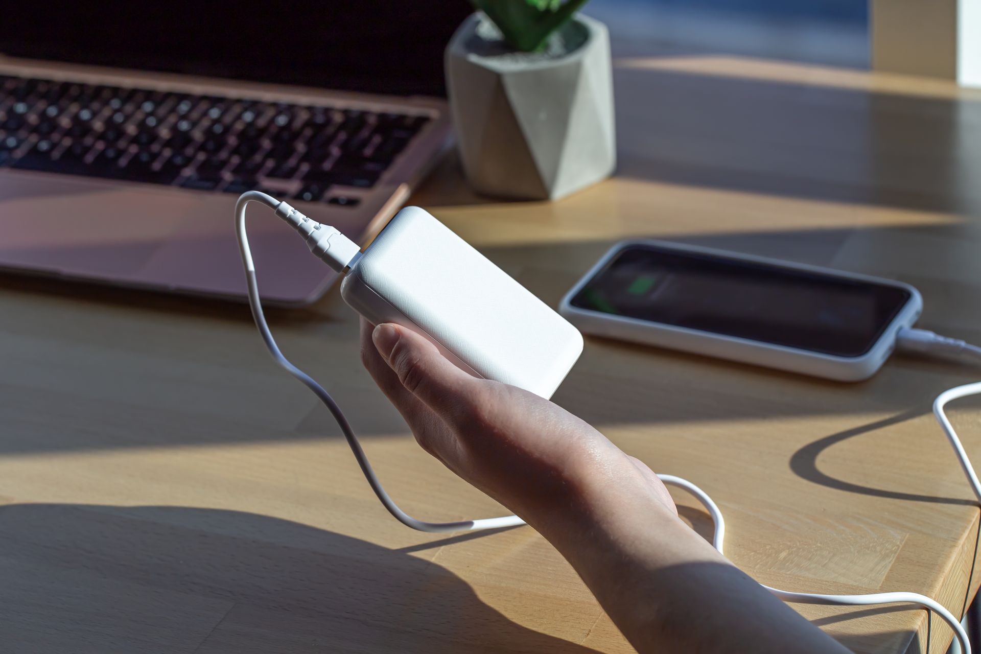 A Person Holding a Powerbank Connected to a Phone