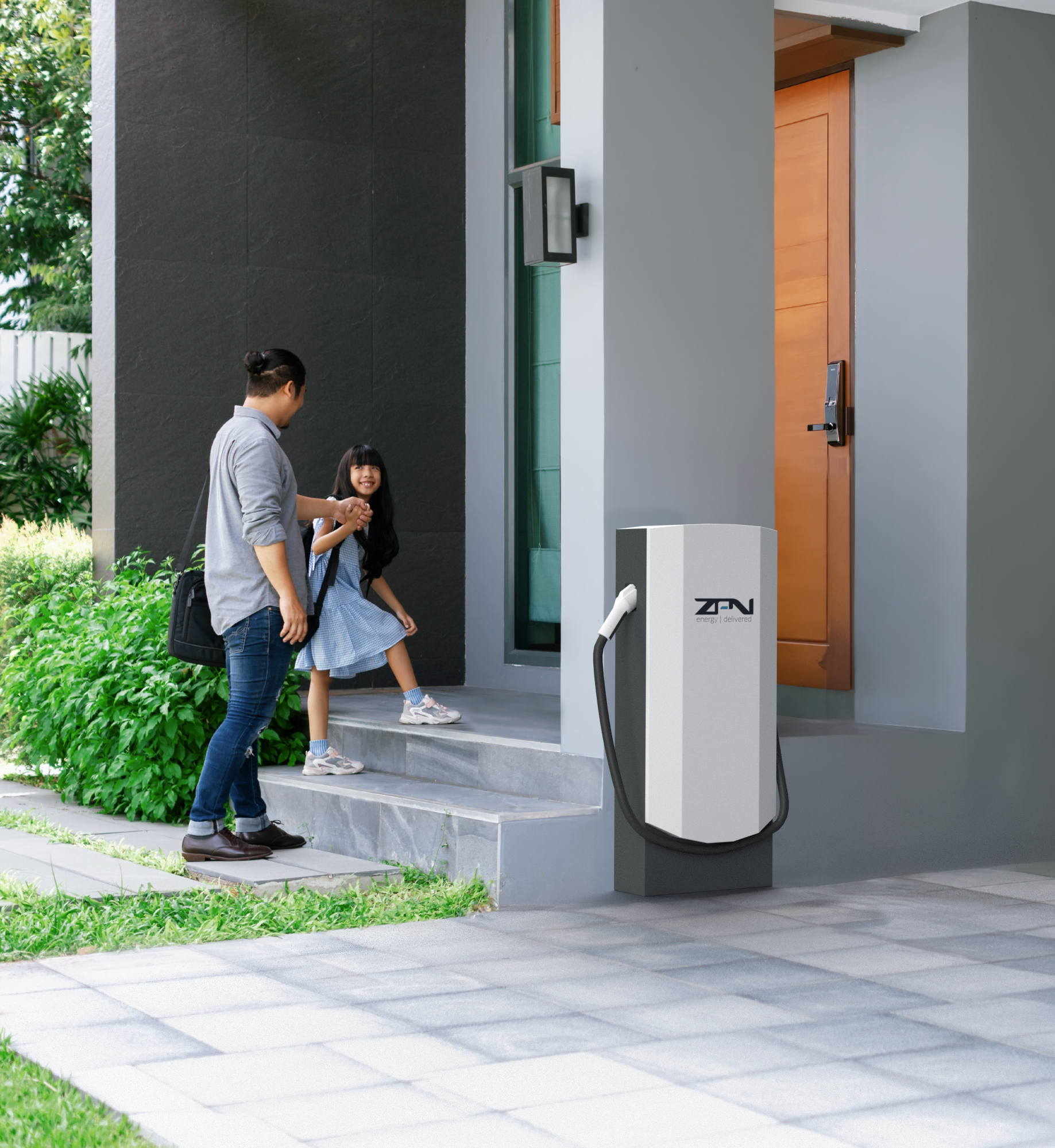 A man and a little girl are standing in front of a zen charging station