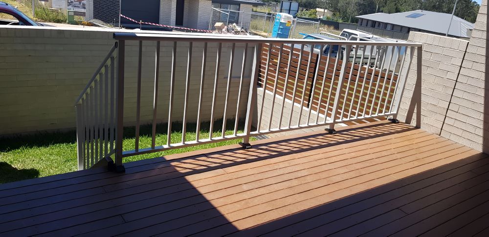 A Deck With A Metal Railing And A Wooden Floor — Metal Fencing Supplies in Mid North Coast, NSW