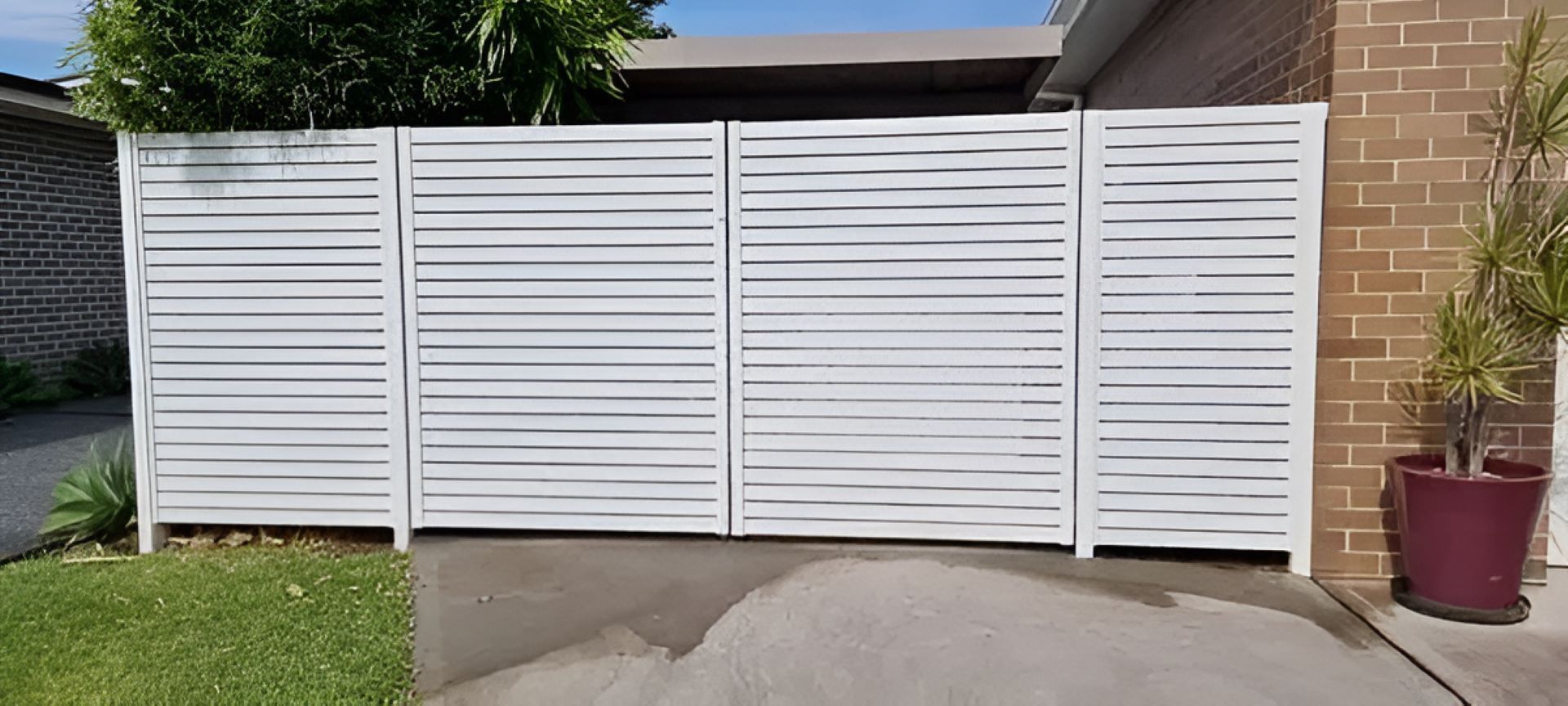 A brick house with a slat fence in front of it — Metal Fencing Supplies in Taree, NSW