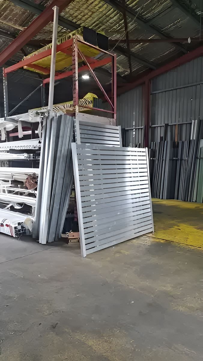 A Warehouse Filled With Lots Of Aluminum Fence — Metal Fencing Supplies in Forster, NSW