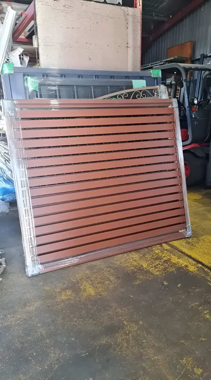 Slat Fence Is Sitting On The Ground In A Warehouse — Metal Fencing Supplies in Taree, NSW