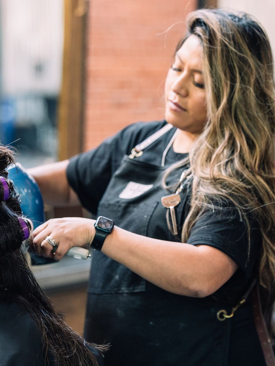 Esmeralda blowdrying a client's hair