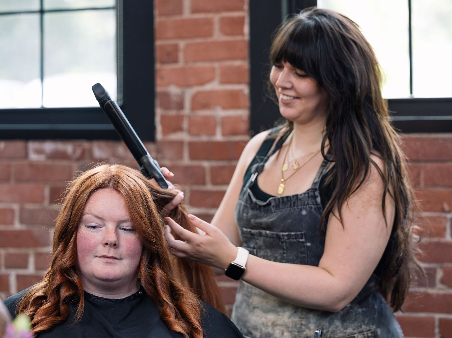 Greta curling a client's hair