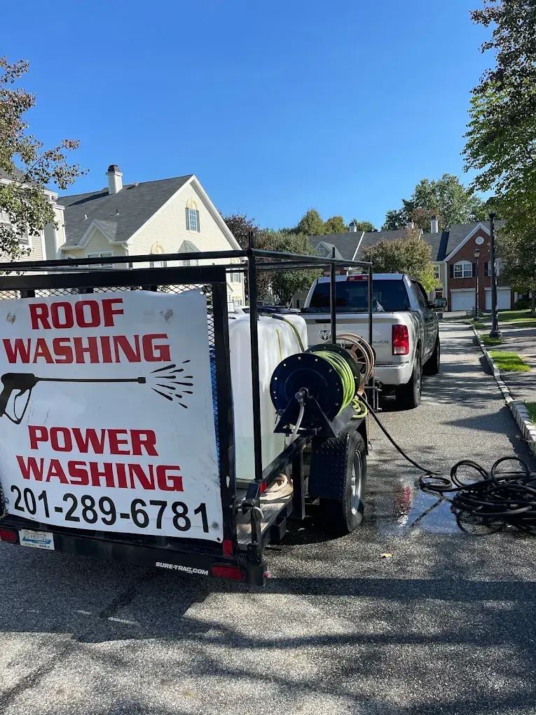 Roof washing and power washing trailer parked on street. 201-289-6781 phone number visible.