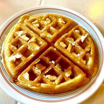 A plate of waffles with syrup and butter on it