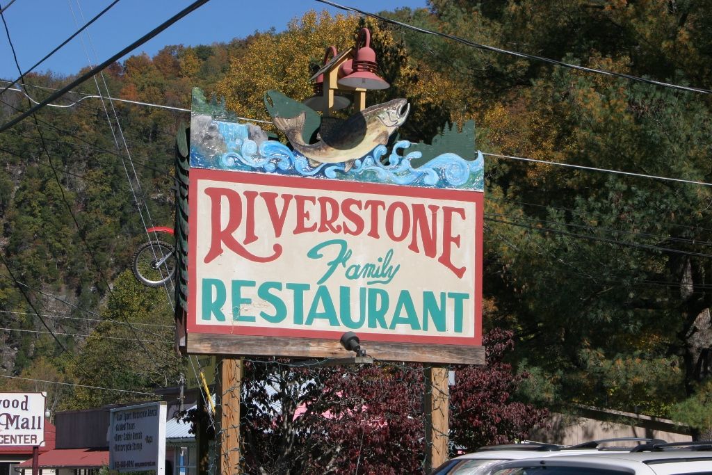 A riverstone family restaurant sign with a fish on it