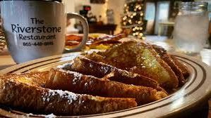 A plate of french toast with powdered sugar and a cup of coffee on a table.