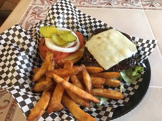 A hamburger and french fries on a checkered paper on a plate