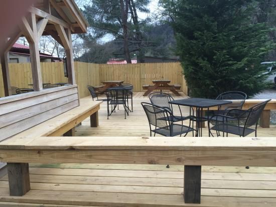 A wooden deck with tables and chairs on it