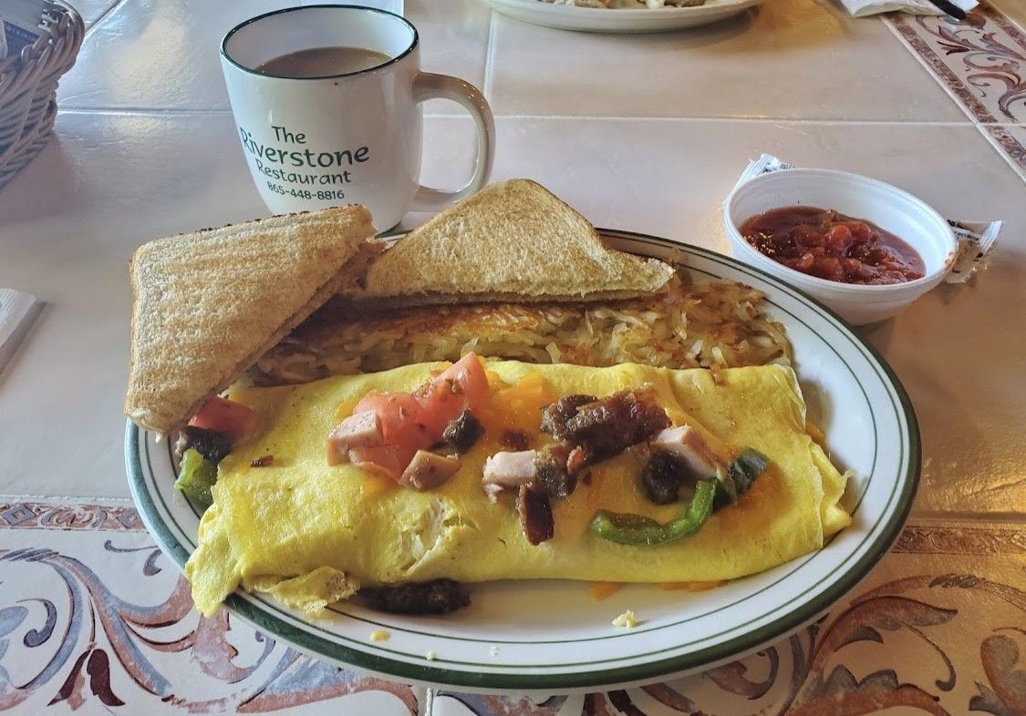 A plate of food with a cup of coffee on a table.
