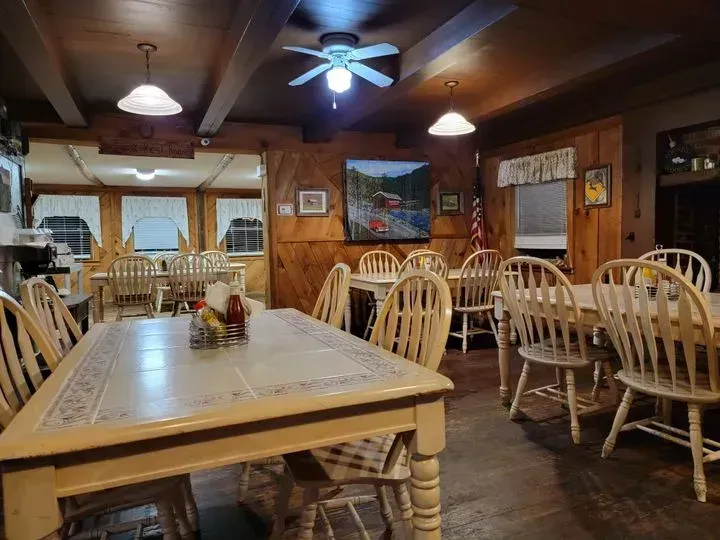 A restaurant with tables and chairs and a ceiling fan.