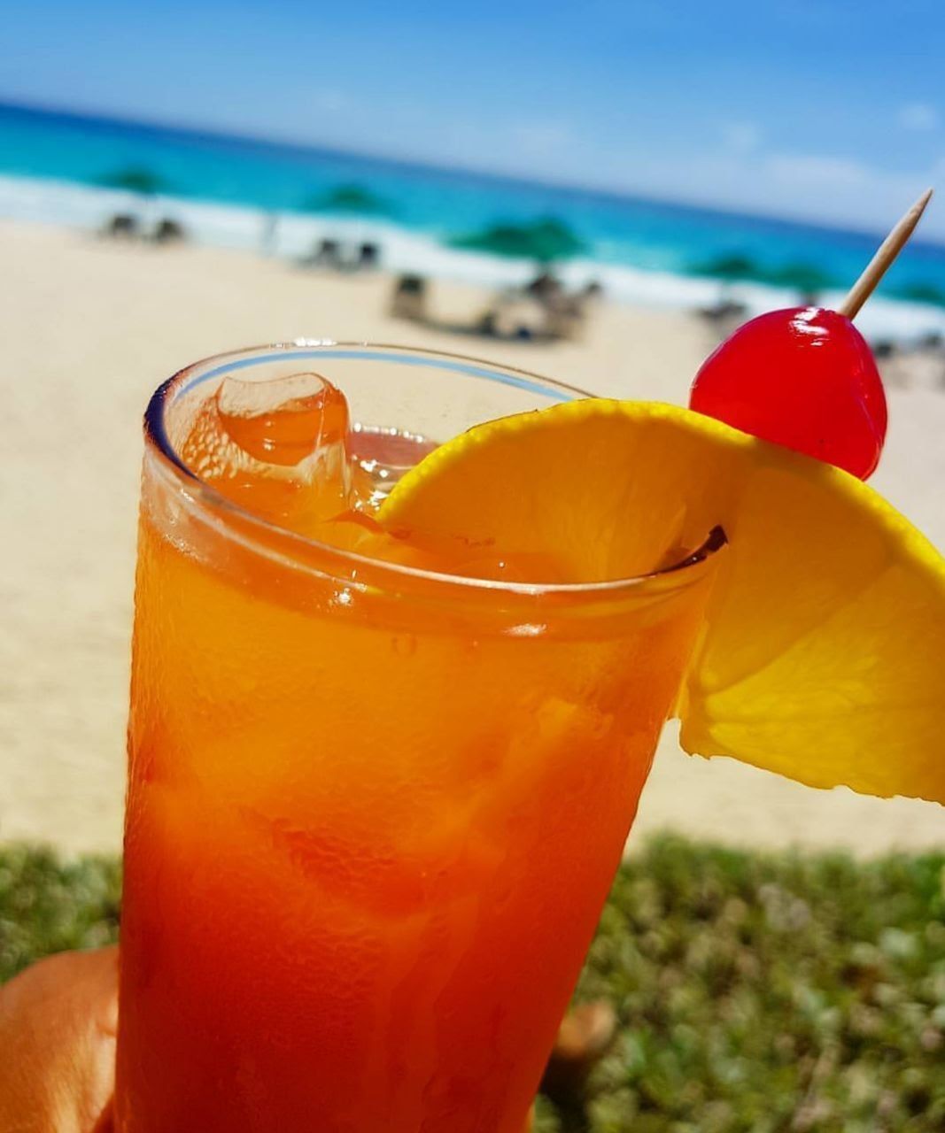 A close up of a drink with a cherry on top