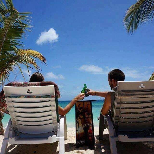 A man and a woman are sitting in chairs on the beach