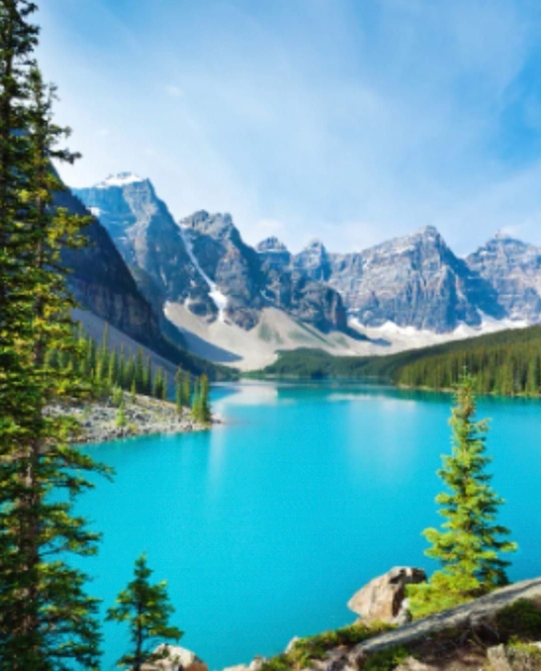 A lake with mountains in the background and trees in the foreground