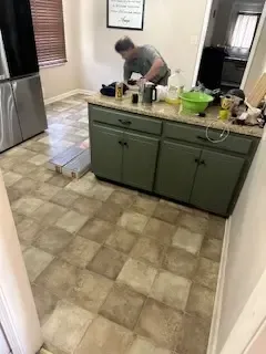 A man is working on a counter in a kitchen.