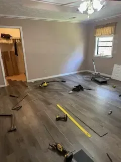A room with a lot of tools on the floor and a ceiling fan.
