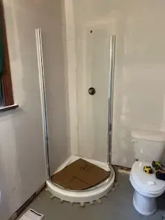 A bathroom with a toilet and a shower stall.
