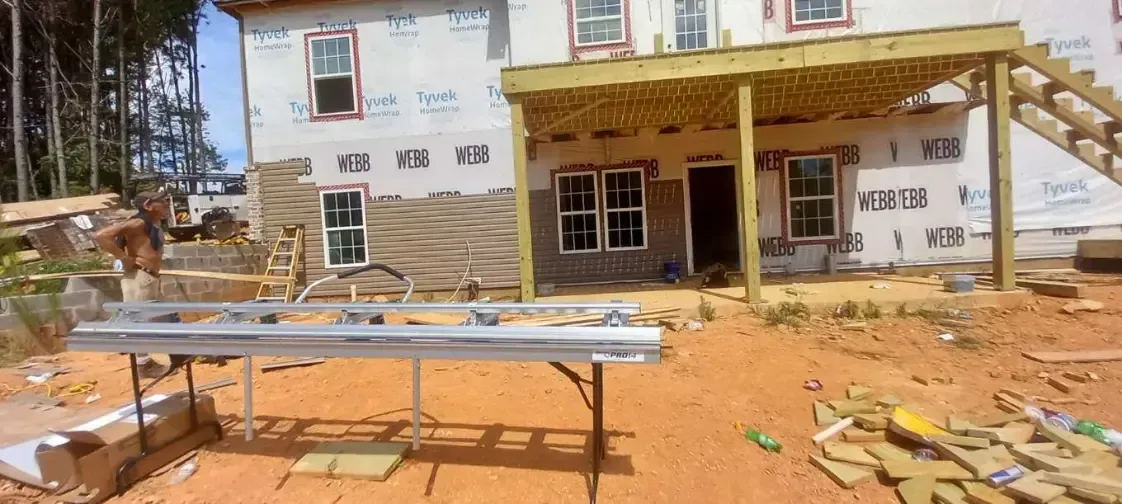 A house is being built with a wooden deck and stairs.
