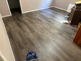 A room with a wooden floor and a vacuum cleaner on the floor.