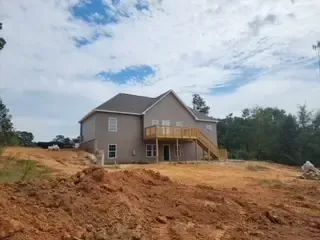 A house is being built on top of a dirt hill.