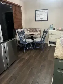 A kitchen with a table and chairs and a refrigerator.