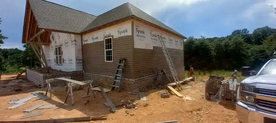 A house is being built in the middle of a dirt field.