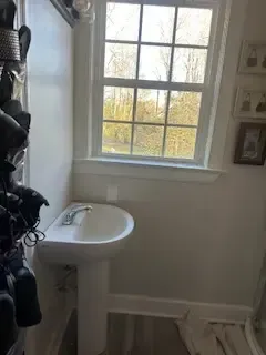 A bathroom with a sink and a window.