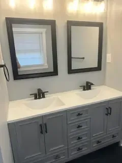 A bathroom with two sinks and two mirrors.