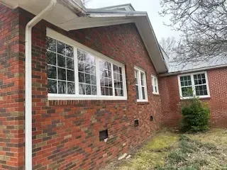 A brick house with a lot of windows on the side of it.