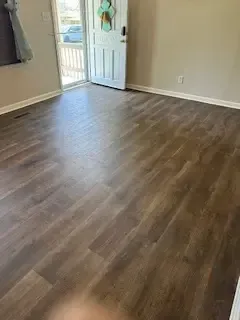 A living room with hardwood floors and a door.