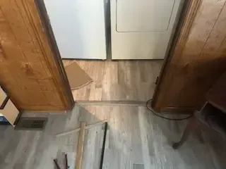 A laundry room with hardwood floors and a washer and dryer.